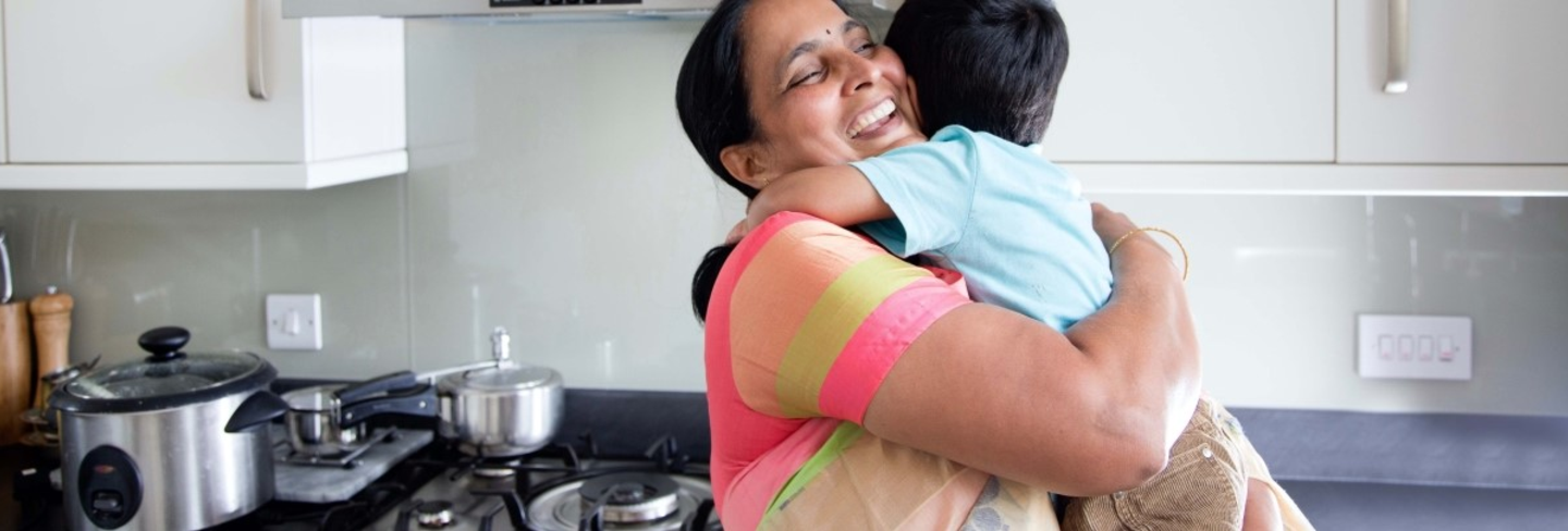 mother hugging her son in the kitchen 